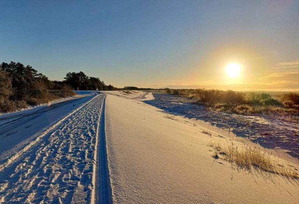 Schneebedeckter Deich bei strahlendem Sonnenschein